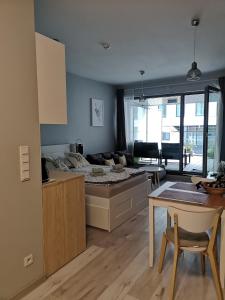 uma cozinha e sala de estar com uma cama e uma mesa em Apartament Gran nad Motławą em Gdansk