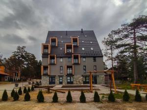 a building with a black roof on top of it at Apartman Maslacak in Divčibare