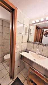 a bathroom with a sink and a toilet and a mirror at Driopon Apartment in Athens