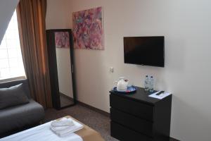 um quarto de hotel com uma cama e uma televisão de ecrã plano em Bursztynowa em Łuków
