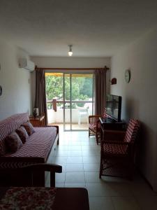 a living room with a couch and a television and a patio at MAR DEL ESTE III PUNTA DEL ESTE in Punta del Este