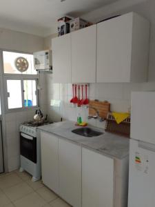 a kitchen with white cabinets and a sink and a stove at MAR DEL ESTE III PUNTA DEL ESTE in Punta del Este +7 photos