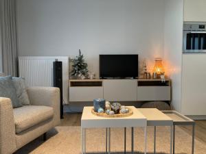 ein Wohnzimmer mit einem Tisch und einem TV in der Unterkunft Alegria Newport in Koksijde