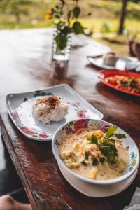 un tavolo con piatti di cibo e una ciotola di zuppa di Sumatra Cheeky Monkeys a Bukit Lawang