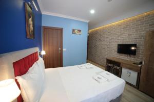 イスタンブールにあるTaksim Park Suitesのベッドルーム1室(ベッド1台、壁にテレビ付)