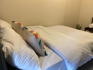 een wit bed met 2 kussens erop bij Fairway Terraces Resort Staycation in Manilla