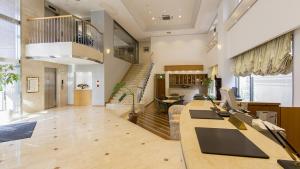 a large room with a staircase and a living room at Imabari Urban Hotel in Imabari