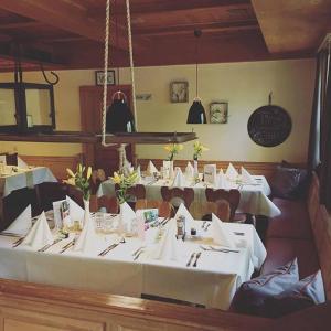 een eetkamer met tafels en stoelen met witte tafellakens bij Hotel Waldvogel in Leipheim