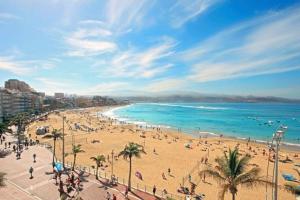 a beach with a lot of people and the ocean at Loft Sol y Luna en Las Palmas de Gran Canaria in Las Palmas de Gran Canaria