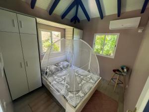 1 dormitorio con 1 cama con dosel de cristal en AWMONY'KAZ, Gite à Trois-Rivières GUADELOUPE en Trois-Rivières