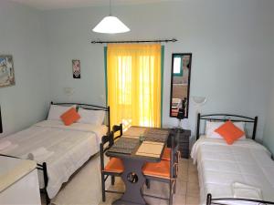 ティロスにあるMouragio Apartmentsのベッド2台とテーブルが備わる客室です。