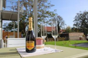 a bottle of champagne and two wine glasses on a table at Willy´s Ferienzimmer im Tabakdorf Hatzenbühl in Hatzenbühl