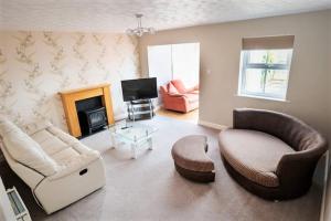 sala de estar con sofá, sillas y TV en Quiet 2 Bedroomed Cottage, near the Lakes en Carnforth