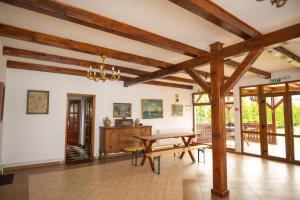 sala de estar con mesa de madera y banco en Pensiunea Sachsenhof, en BÄƒgaciu