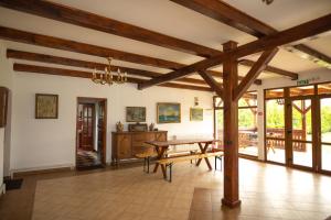 comedor con mesa y vigas de madera en Pensiunea Sachsenhof, en BÄƒgaciu 47 fotos más