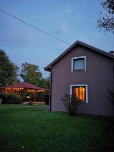a house with lights in the window of a yard at Kuća za odmor Rubić in Vinkovci