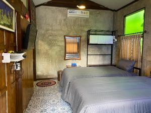 - une chambre avec un lit et une télévision dans l'établissement Nokkamin Home, à Chiang Dao