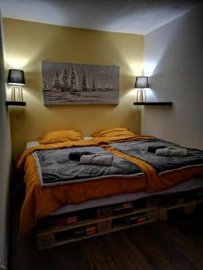 een slaapkamer met een bed met twee lampen aan de muur bij Kuća za odmor Rubić in Vinkovci