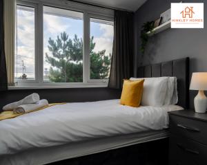 a bedroom with a bed with yellow pillows and a window at Large & Spacious 3 Bedroom House with Parking & Wifi By Hinkley Homes Short Lets & Serviced Accommodation in Liverpool