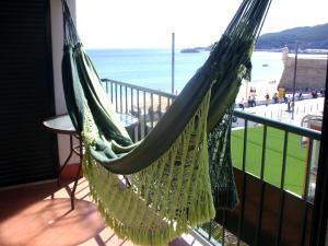 a hammock hanging from a balcony overlooking the beach at Sesimbra4you in Sesimbra