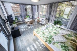 a bedroom with a bed and a living room with windows at Atelier Lanna in České Budějovice