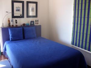 1 dormitorio con 1 cama azul con sábanas azules en Sesimbra4you, en Sesimbra