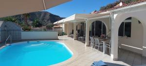 a swimming pool on a patio with a house at Villa Tauro Beach & Golf in La Playa de Tauro