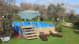 een zwembad met een ladder en een parasol bij Terreno Ro-Bi-Li Ferienwohnung in Cutrofiano