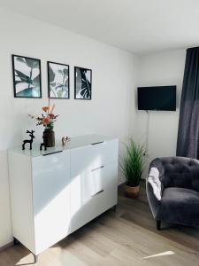 un armario blanco y una silla en una habitación en Zollernalb-Apartment MG, en Albstadt
