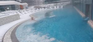 una persona en una piscina en la nieve en Apartament z widokiem na morze Międzyzdroje, en Międzyzdroje