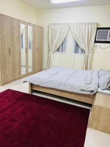 FANATEER SUDAYER VILLA في Al Fanātīr: غرفة نوم بسرير ونافذة كبيرة