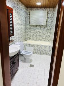 FANATEER SUDAYER VILLA في Al Fanātīr: حمام مع مرحاض ومغسلة وحوض استحمام