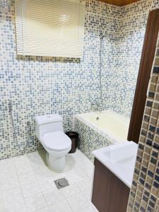 FANATEER SUDAYER VILLA في Al Fanātīr: حمام مع مرحاض وحوض استحمام ومغسلة