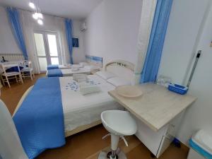 a bedroom with two beds and a desk and a chair at Casa di Sofia in Castellana Grotte