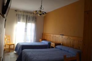 um quarto com 2 camas e uma janela em Casa Rural "La Cerecera" em Los Navalucillos