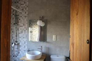 uma casa de banho com um lavatório, um WC e um espelho. em Casa Rural "La Cerecera" em Los Navalucillos