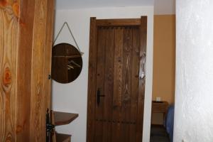 a hallway with a wooden door and a mirror at Casa Rural "La Cerecera" in Los Navalucillos