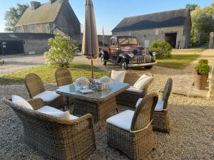 a patio with a table and chairs and an umbrella at Spirit of 1944 in La Cambe