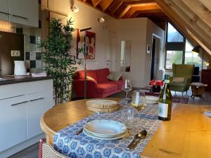 a kitchen and living room with a table with a bottle of wine at Gastenverblijf Chambre dAmis in Heers