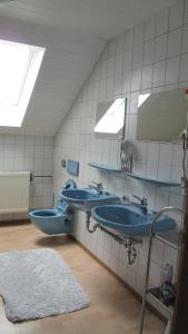 a bathroom with two blue sinks and a mirror at Haus Resi in Mähring