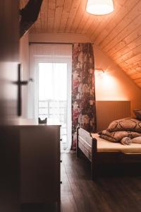 een slaapkamer met een bed in een kamer met een raam bij LB Domek w centrum Willowa 3 in Szczyrk