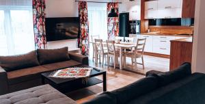 a living room with a couch and a table and a kitchen at LB Domek w centrum Willowa 3 in Szczyrk