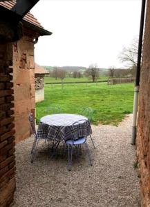 une table et des chaises assises sur une terrasse dans l'établissement Gîte du four à pain, à Couzon