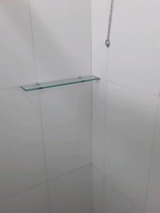 una puerta de ducha de cristal con una estantería de cristal en Star Hotel en Juiz de Fora