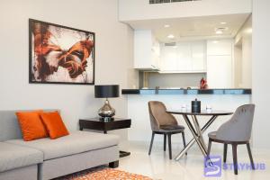 a living room with a couch and a table at Gorgeous Apt In DAMAC HILLS - Golf View in Dubai