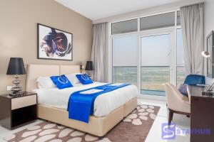 a bedroom with a bed and a desk and a window at Gorgeous Apt In DAMAC HILLS - Golf View in Dubai