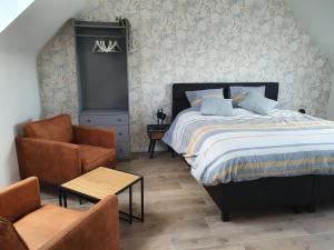 a bedroom with a bed and a chair at B&B Dekorn in Pepingen