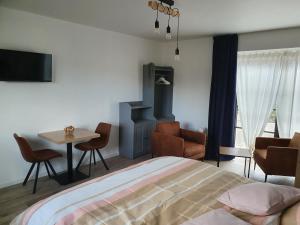 a bedroom with a bed and a table and chairs at B&B Dekorn in Pepingen