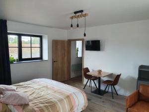 a bedroom with a bed and a table with chairs at B&B Dekorn in Pepingen