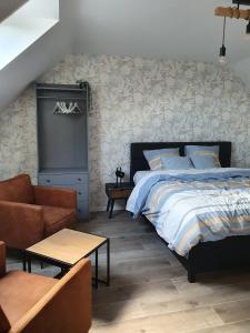 a bedroom with a bed and a couch and a chair at B&B Dekorn in Pepingen